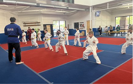 A kids class training on the blue and red mats