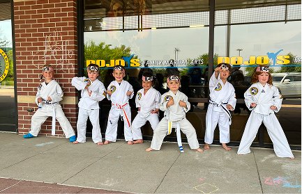 Kids in uniform posing in front of the Johnston dojo