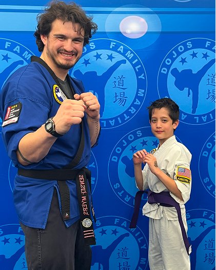 Sensei Noah Myers training with a student in front of the Dojo's wall